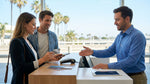 Close-up of hands holding a smartphone and numberless credit card at a car hire counter in California