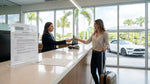 A traveler handing a credit card to an agent at a car rental desk in Orlando