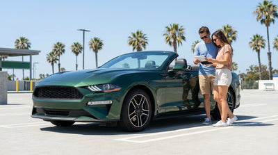A car hire driving on the scenic Pacific Coast Highway in California, with cliffs on one side and the ocean on the other