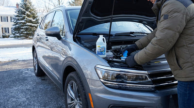 A driver tops up the winter washer fluid on a car hire vehicle on a snowy day in Pennsylvania