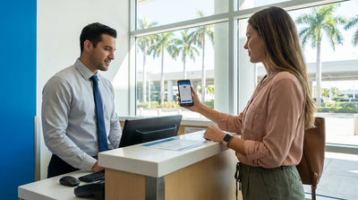 A person at a Miami airport desk shows a mobile phone to complete their car rental pickup
