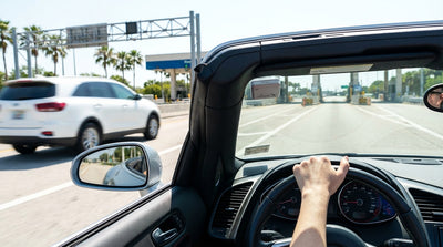 A car rental driving under a SunPass electronic toll sign on a multi-lane highway in Florida