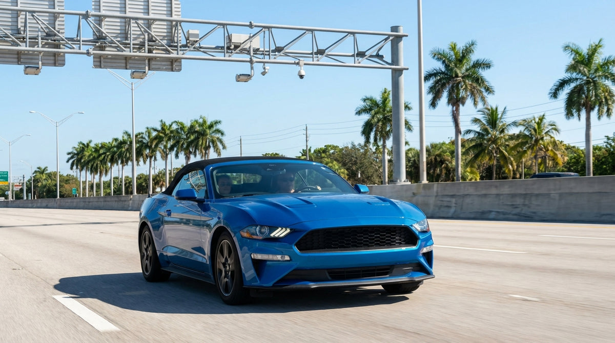 A car rental drives on a sunny Miami highway with signs for the express toll lanes overhead