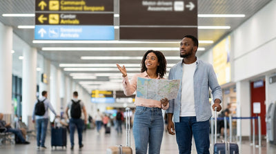 Signs for the AirTrain to the car rental center hang above travelers in the JFK arrivals hall in New York