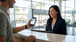 Person showing a digital driving licence on a smartphone at a car rental desk in California