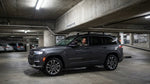 A large SUV car hire in a Los Angeles garage with its roof dangerously close to a low-clearance sign