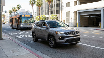 A car hire navigates traffic on a sunny Los Angeles street with a dedicated red bus lane