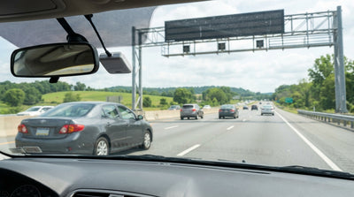 A car rental driving through the scenic rolling hills of Pennsylvania on a sunny highway