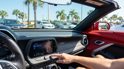 Driver's hand on the touchscreen display of a modern car rental dashboard in Orlando