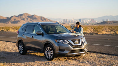 A car hire on a desert road driving away from the Las Vegas skyline into the mountains at sunset