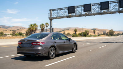 A car hire driving down a sunny Orange County toll road with California's golden hills in the background