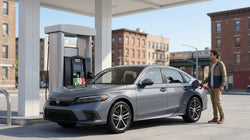 Person holding a fuel pump nozzle filling a car hire vehicle at a New York gas station