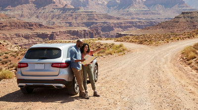 A car hire driving on a desert highway towards mountains for a road trip leaving Las Vegas