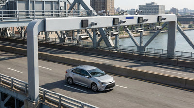 A car hire crossing a bridge into New York City with the downtown skyline visible in the distance