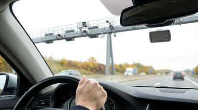 A New York car hire approaching a cashless toll gantry on a highway under a clear blue sky