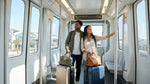 A traveler with bulky suitcases looks for their car hire service outside the sunny Miami International Airport terminal