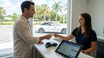 Close up of a hand passing a credit card to an agent at a car hire counter in Florida