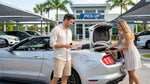 A traveler at a Florida airport car rental desk handing over a credit card to collect their vehicle
