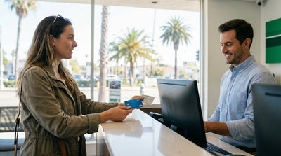 A red convertible car rental drives along the scenic Pacific Coast Highway in California with ocean views