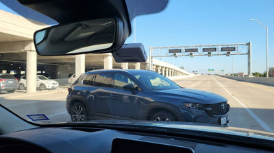 A driver's view from their car rental of a multi-lane Texas highway and electronic toll signs