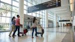 Passengers with luggage walking through Terminal A at Orlando Airport toward the car rental desks