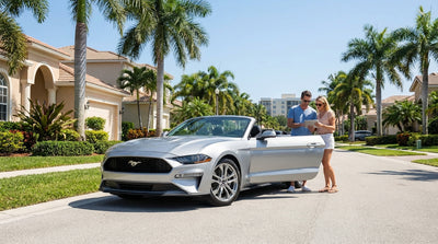A red convertible car hire driving down a scenic coastal highway in Florida with palm trees and ocean views