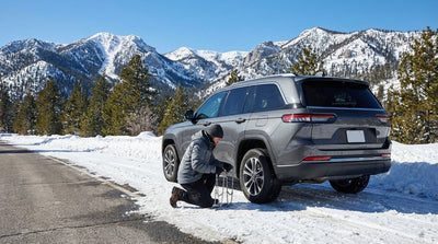 A car rental drives on a scenic, snow-covered road on Mount Charleston, high above the Las Vegas desert