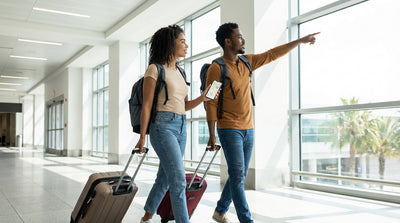 A traveler with luggage stands at a car hire counter inside the bright Orlando Airport terminal