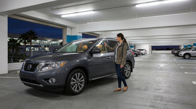 A car in an after-hours car hire return lot at LAX, with the Los Angeles airport terminal lit up in the background