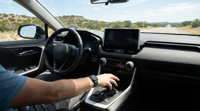 A modern car rental pickup truck navigating a winding, hilly road in Texas