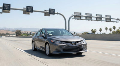 A car hire drives on a busy San Francisco freeway towards the Bay Bridge with express lane signs visible