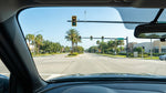 A driver's view from a car hire of a flashing yellow arrow traffic light at a busy Orlando intersection