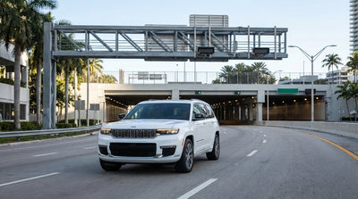 A car hire vehicle driving towards the entrance of the PortMiami Tunnel under a sunny blue sky in Miami