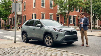 A person using a smartphone to pay for their car hire parking on a city street in Philadelphia