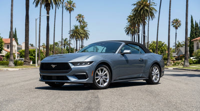 A car rental driving on a freeway towards the downtown Los Angeles skyline on a sunny day