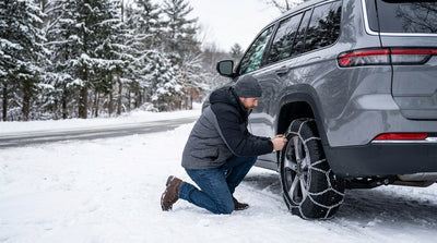 A car hire driving on a snow-covered road surrounded by pine trees in upstate New York