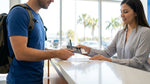 Close up of a customer showing a driver's license to a car hire agent at a service desk in Florida