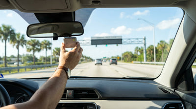 View from inside a car hire on a sunny Florida highway approaching a SunPass toll gantry