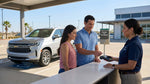A person at a car hire counter in Texas holding a credit card and speaking with an agent