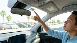 White electronic toll tag mounted to the upper windshield of a Texas car rental