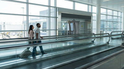 A traveler with luggage at New York's JFK airport follows a sign for the car rental shuttle