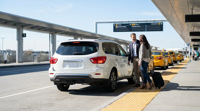 Cars and yellow taxis lined up for passenger pickup at a JFK terminal, a common New York car hire and drop-off point