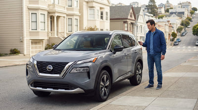 A silver car hire is parked on a steep San Francisco street with the city skyline visible in the background