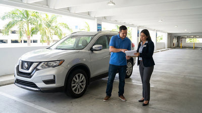 A row of clean vehicles available for car rental inside a brightly lit Miami airport garage