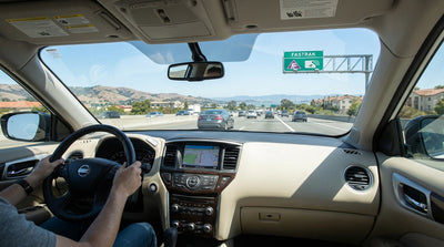 A car hire driving across the Golden Gate Bridge toward San Francisco on a bright, sunny day