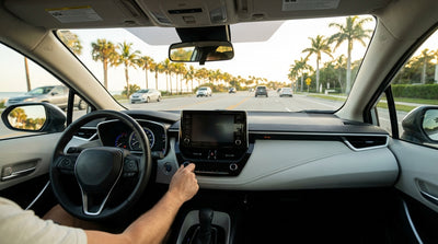 A modern car hire on a coastal highway in Florida, driving towards a vibrant sunset over the ocean