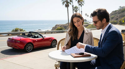 Red convertible car rental driving along California's sunny Pacific Coast Highway