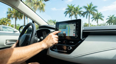 A driver checks the sat-nav screen map in their Florida car rental before starting a trip