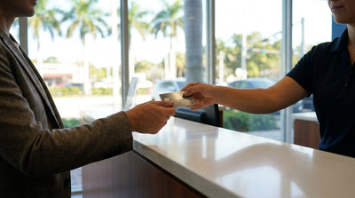 Close up of hands passing a credit card to an agent at a Miami car hire counter