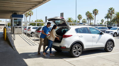 A red convertible car hire driving on Ocean Drive in Miami past palm trees and colorful art deco buildings
